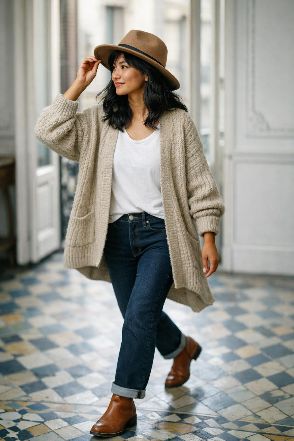 Winter fashion outfits with oversized beige chunky knit cardigan and dark jeans