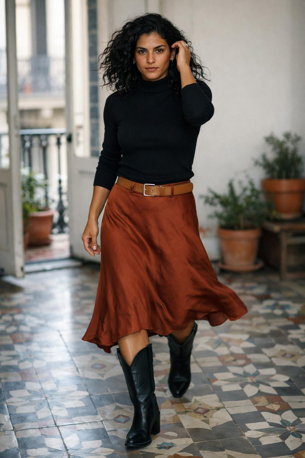 Black cowboy boots outfit with black ribbed turtleneck and rust-colored midi slip skirt