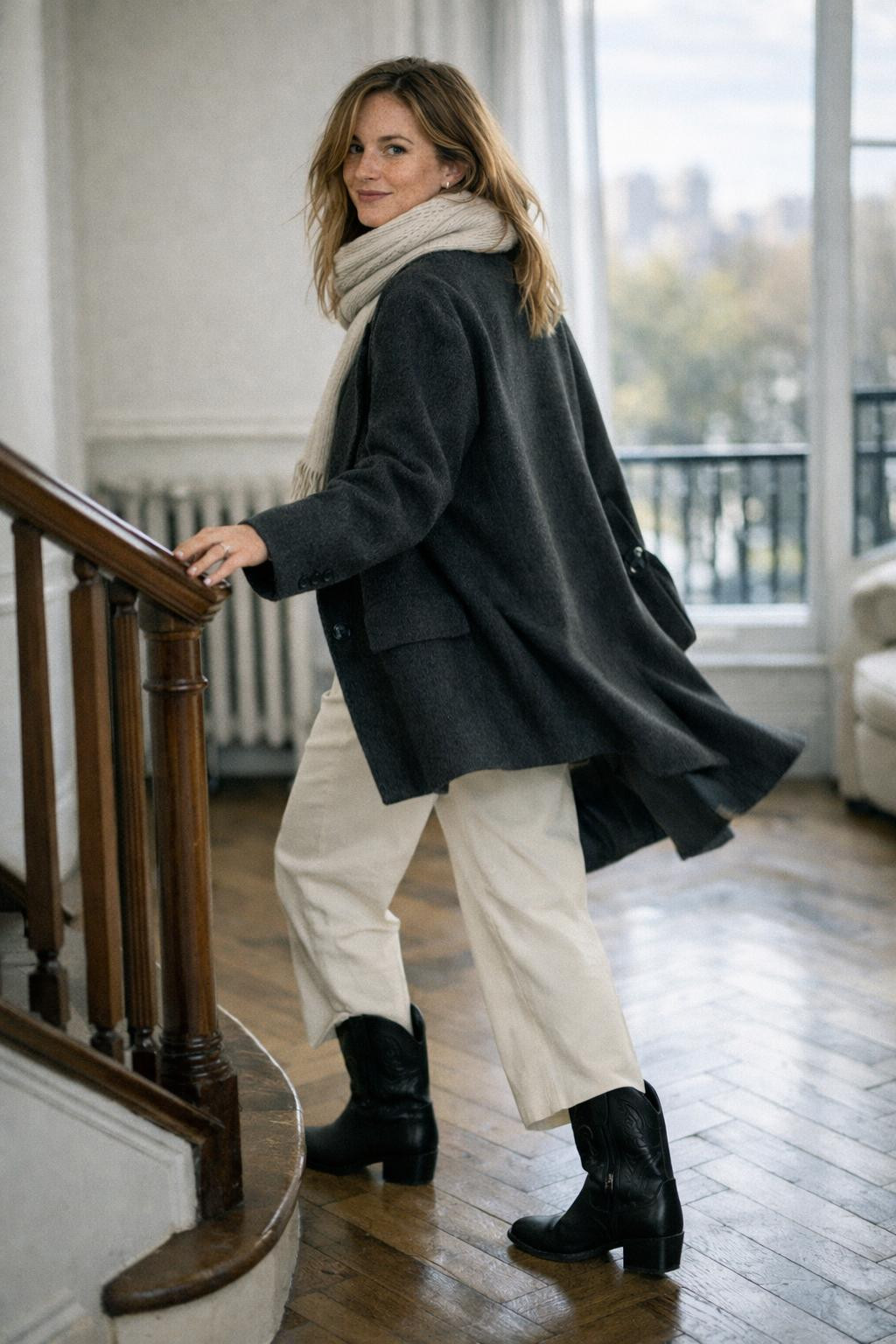 Short cowboy boots outfit styled with cream wide-leg pants and charcoal coat
