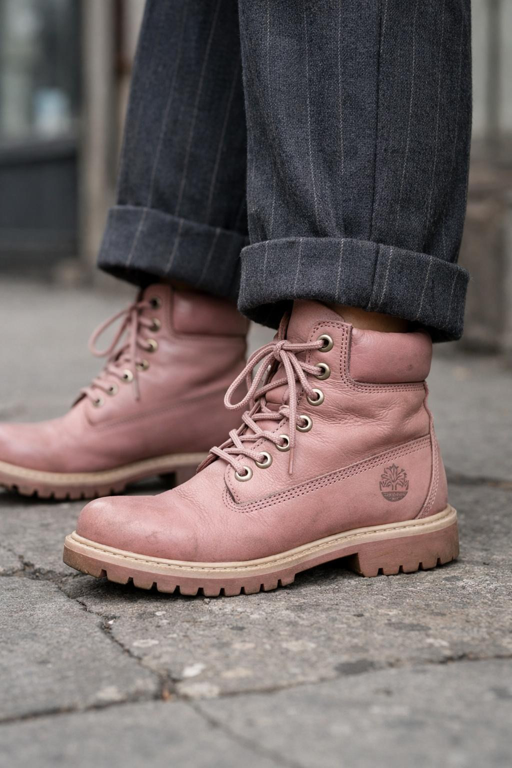 Pink Timberland boots outfit close-up with charcoal pinstripe trousers