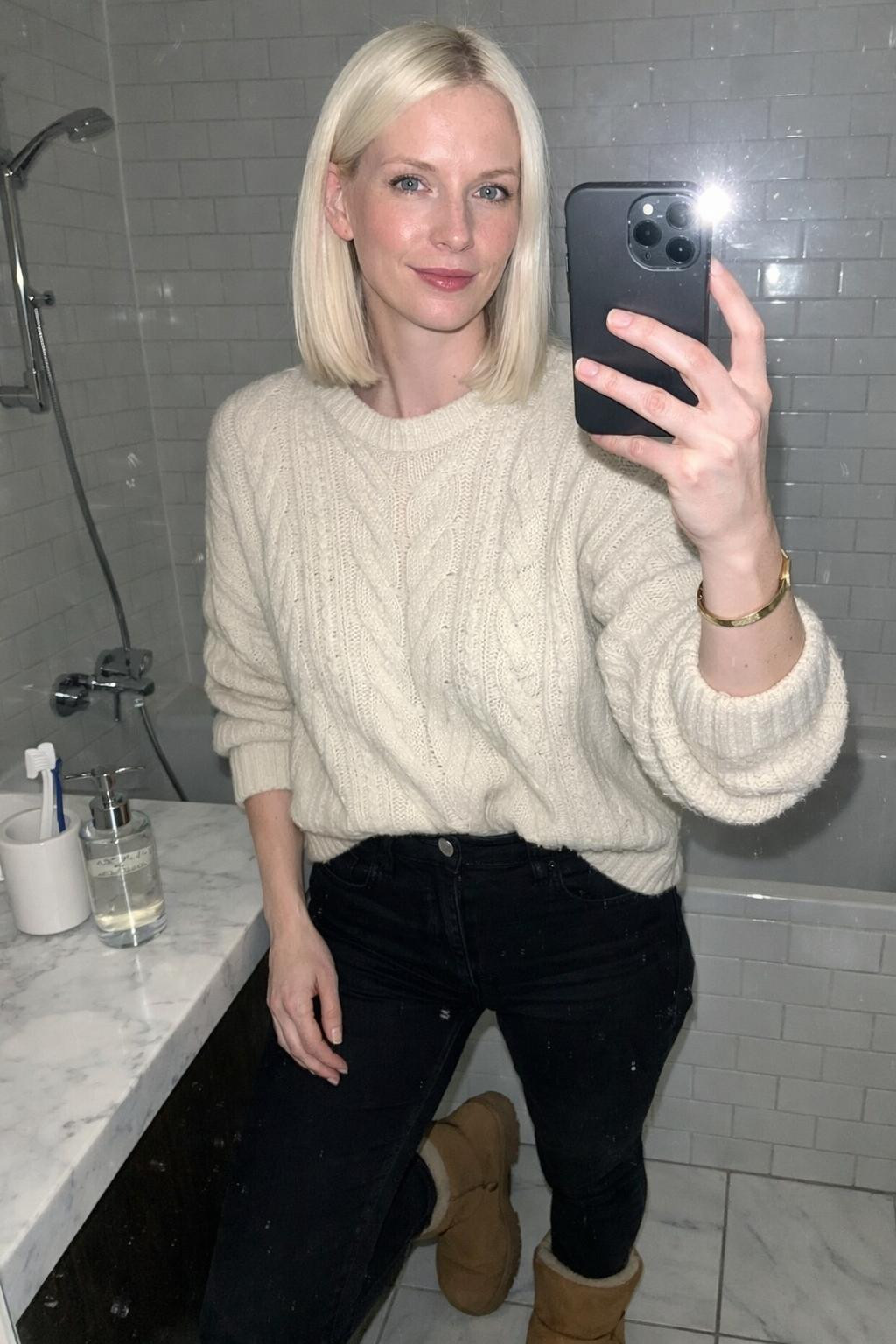 Outfits with Ugg boots styled with oversized cream sweater and black jeans