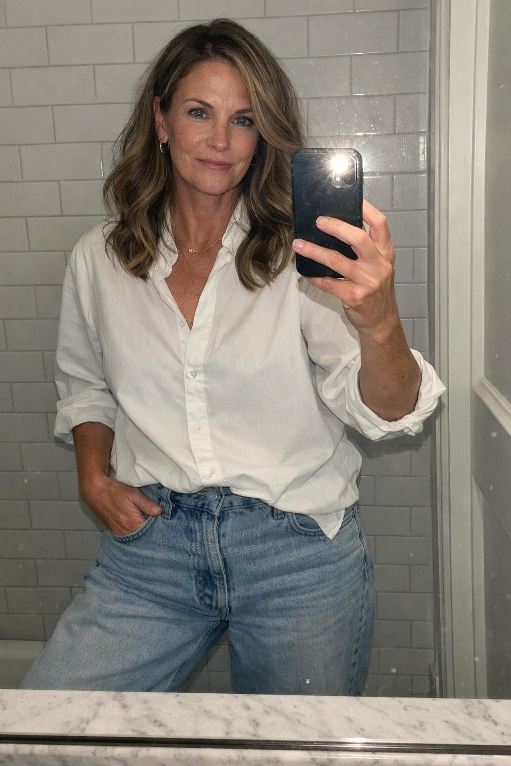 Baggy jeans outfit bathroom mirror selfie with rolled sleeves and minimal jewelry
