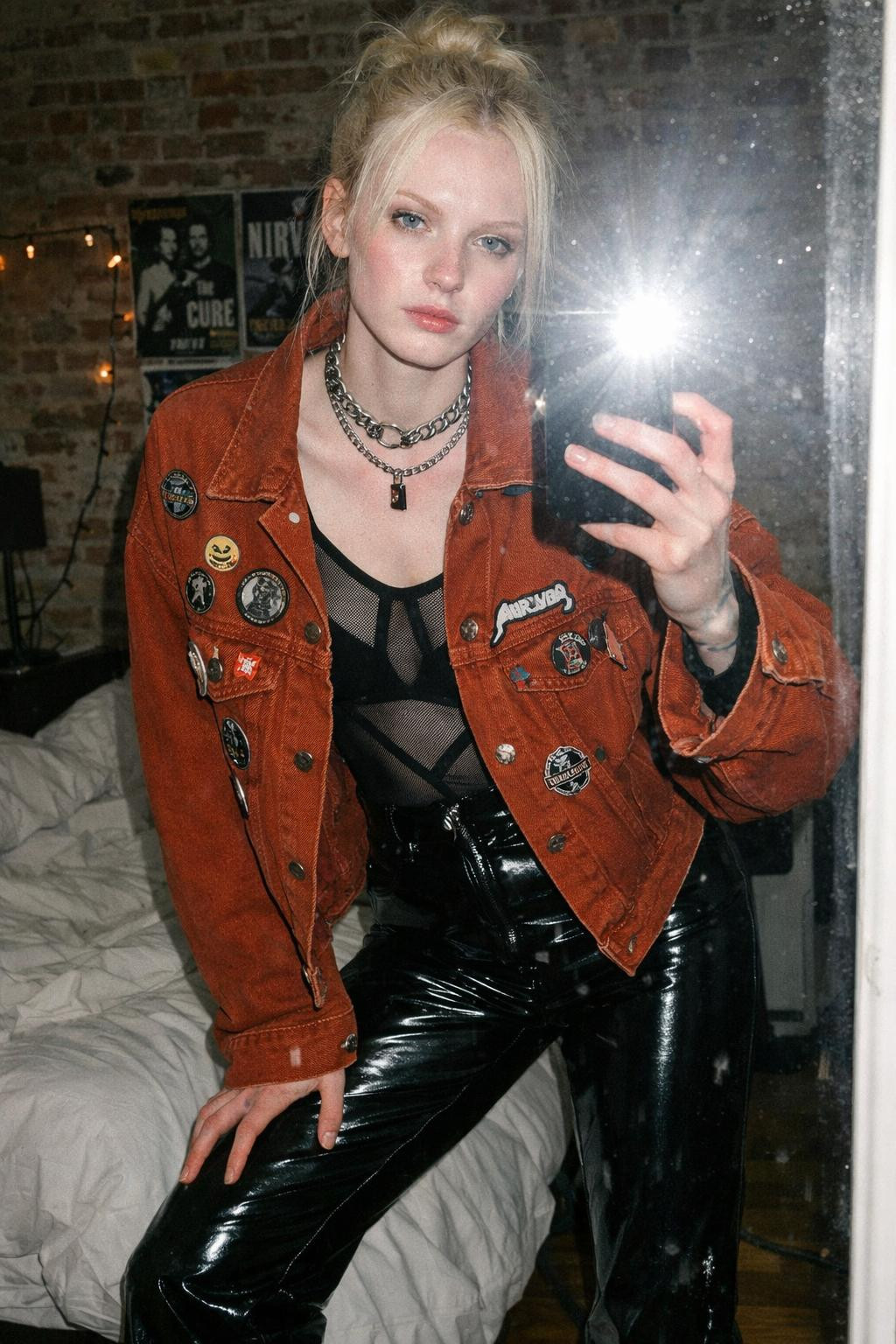 Summer concert outfit with burnt sienna oversized denim jacket over black mesh bodysuit