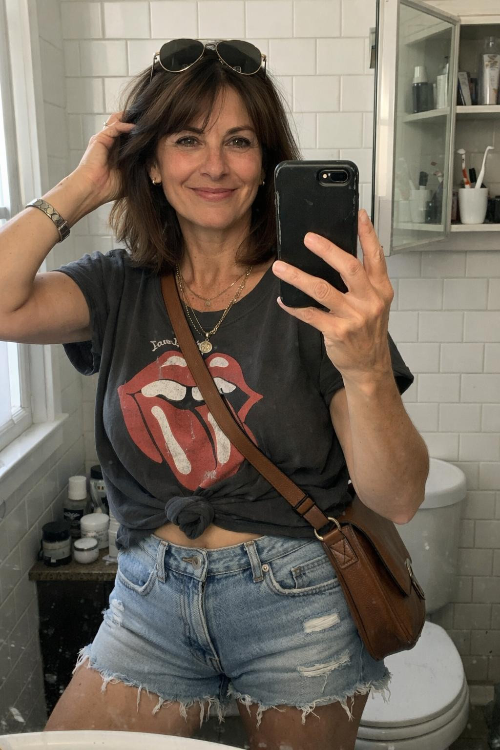 Summer concert outfit with distressed vintage band tee and light-wash denim shorts for mature style