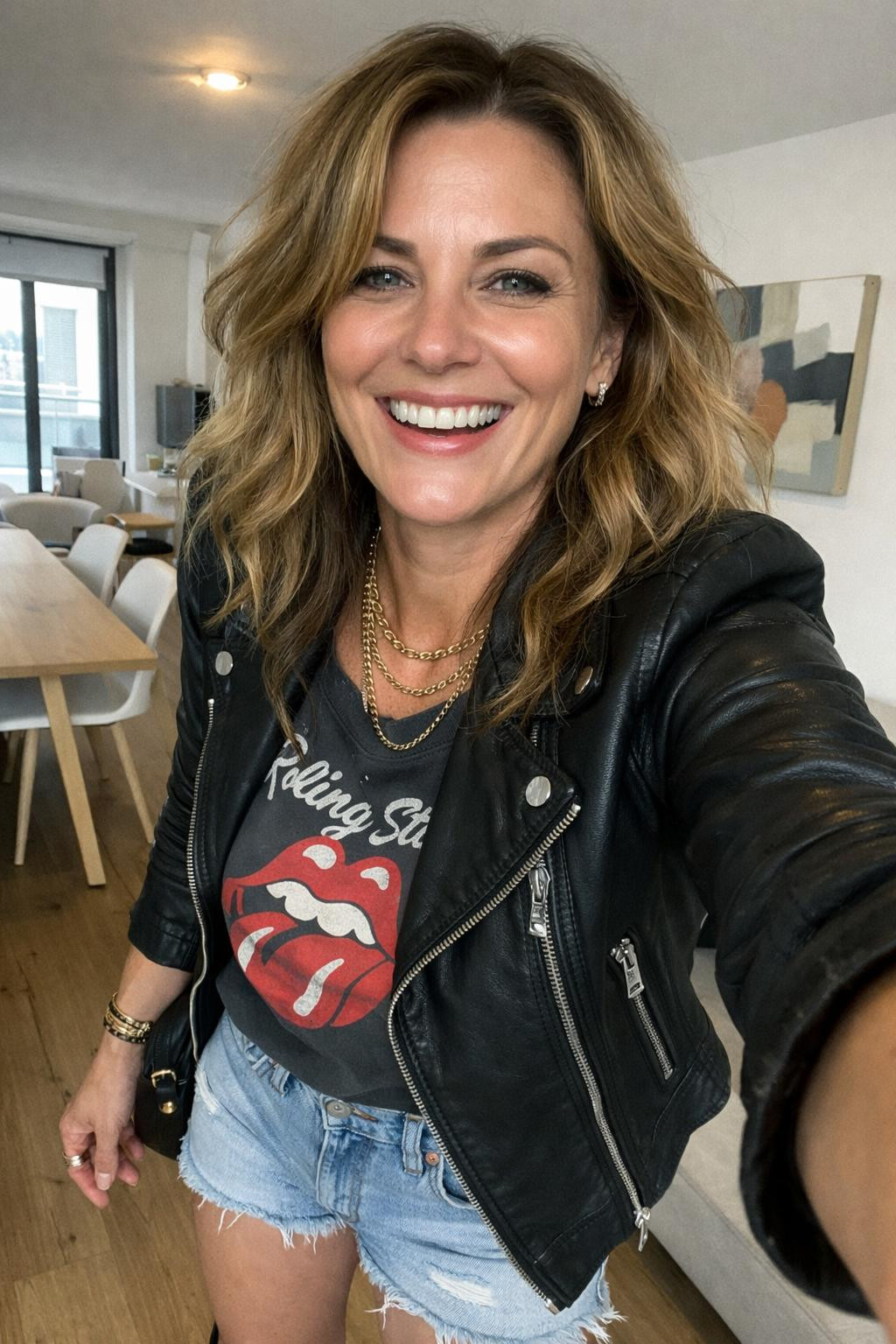 Summer concert outfit with fitted black leather jacket over vintage band tee for mature style