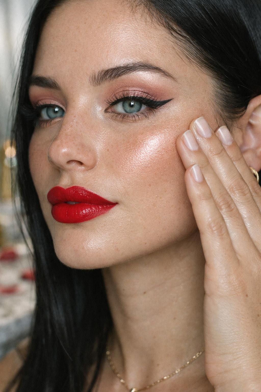 Valentine's Day makeup closeup with bold red lips and gold highlighter