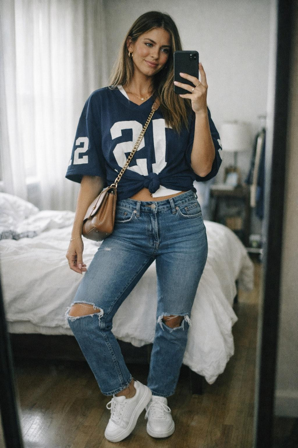 Football game outfit with navy jersey knotted over high-waist denim
