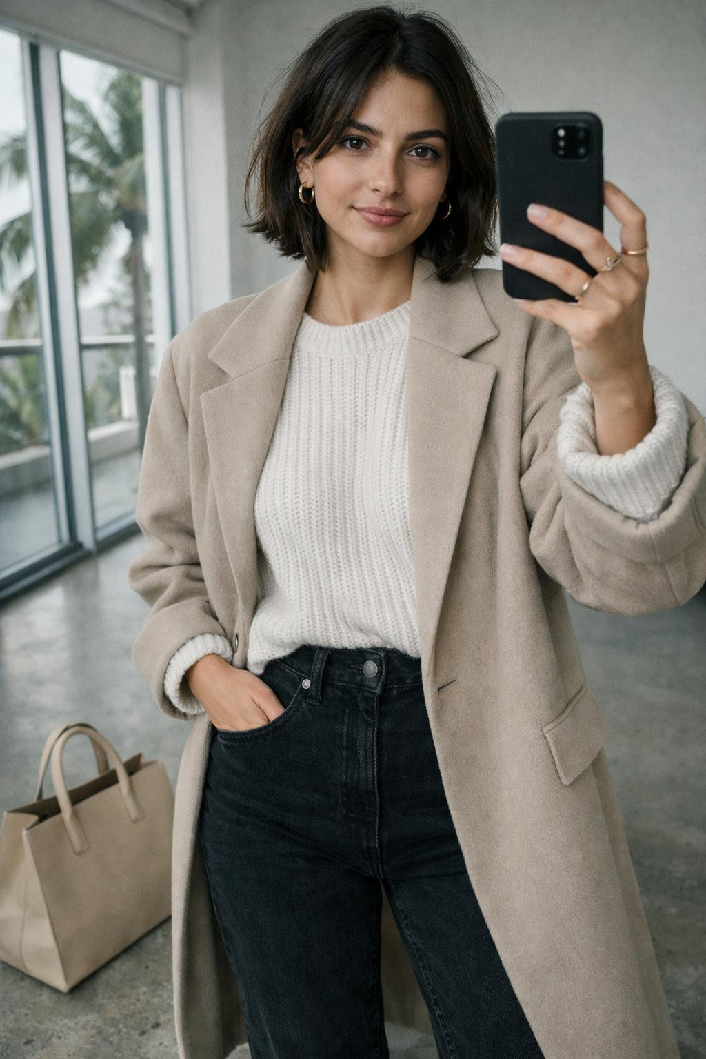 Black jeans outfit with oversized white sweater and beige wool coat