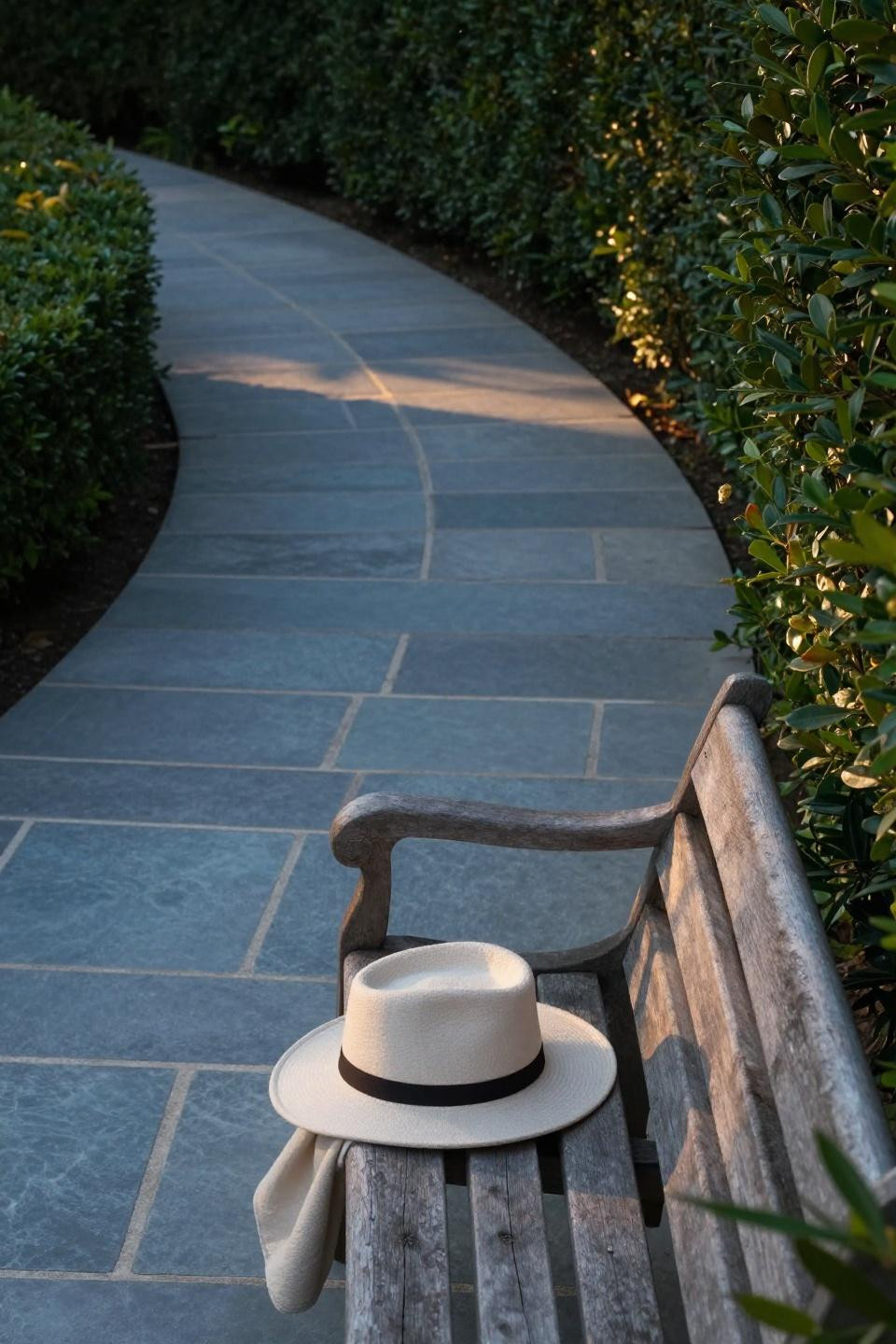 Yard walkway ideas featuring curved bluestone pavers with hand-fitted mortar joints flanked by mature boxwood hedges