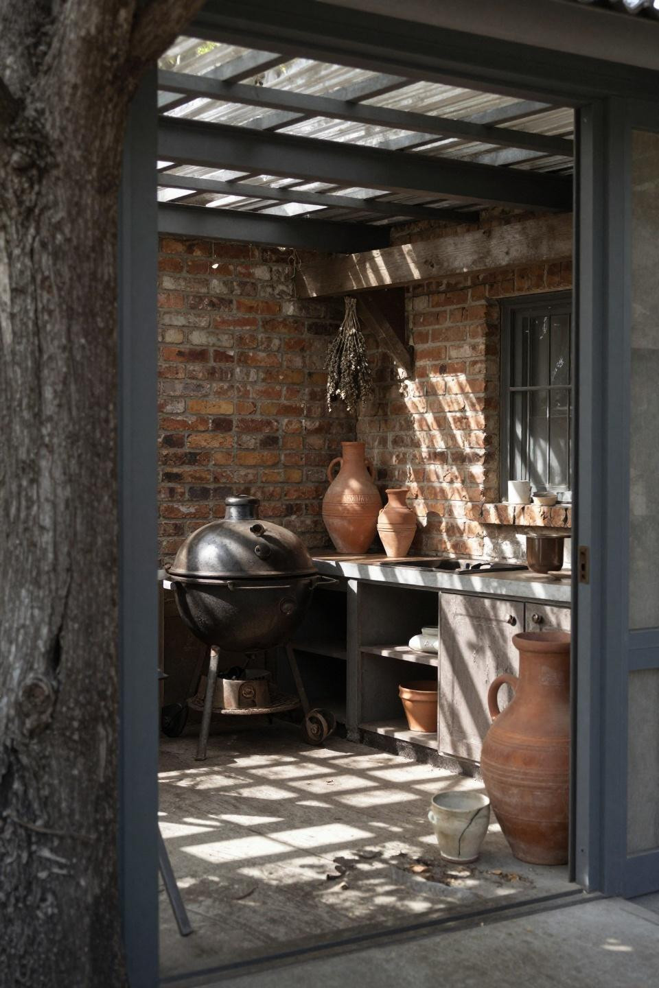 Intimate covered outdoor kitchen nook with reclaimed brick facade and simple steel frame pergola