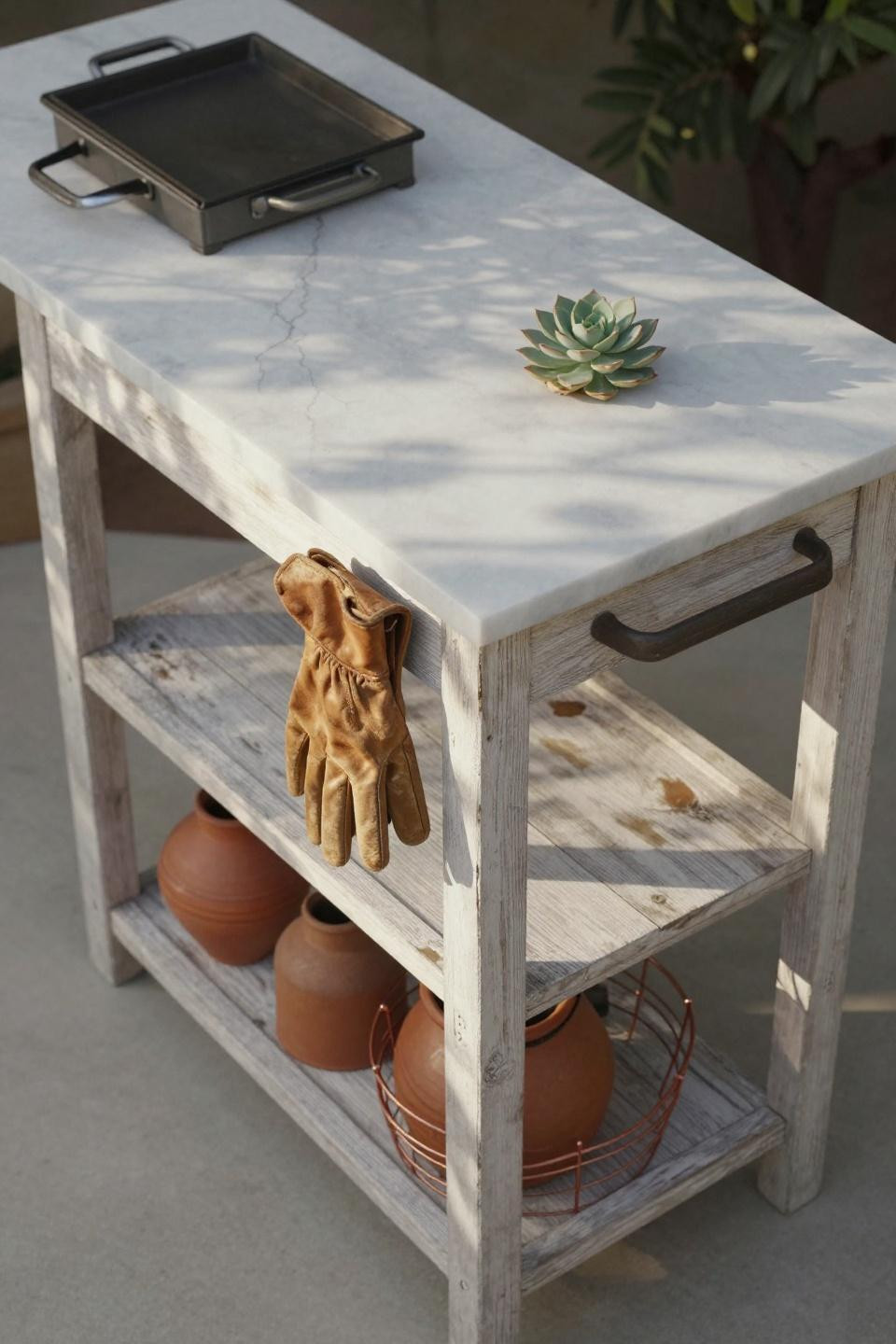 Salvaged whitewashed timber outdoor kitchen cart with cast-iron griddle on honed Italian marble