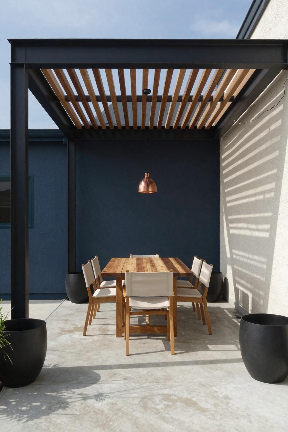 Covered deck ideas with modern blackened steel pergola and geometric shadow patterns
