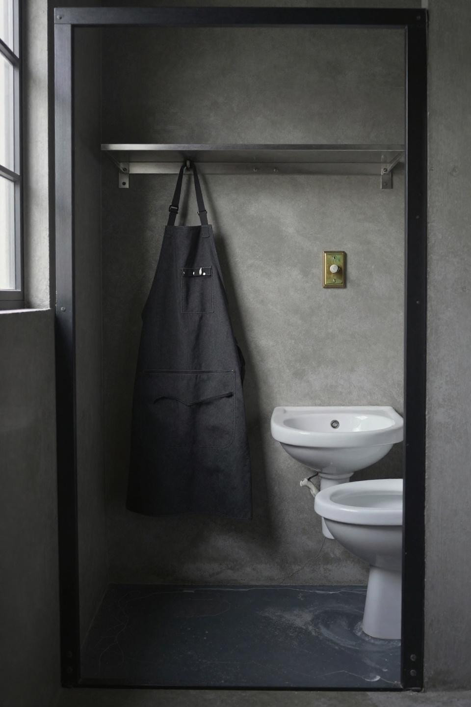 Small toilet design ideas with raw industrial steel frame and concrete floor