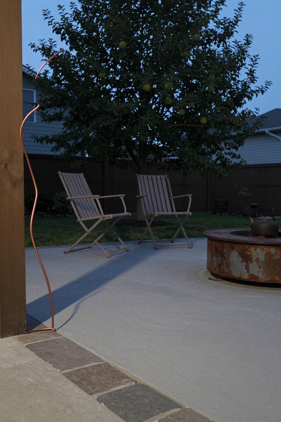 Back patio concrete ideas with hand-trowel finish and steel fire pit