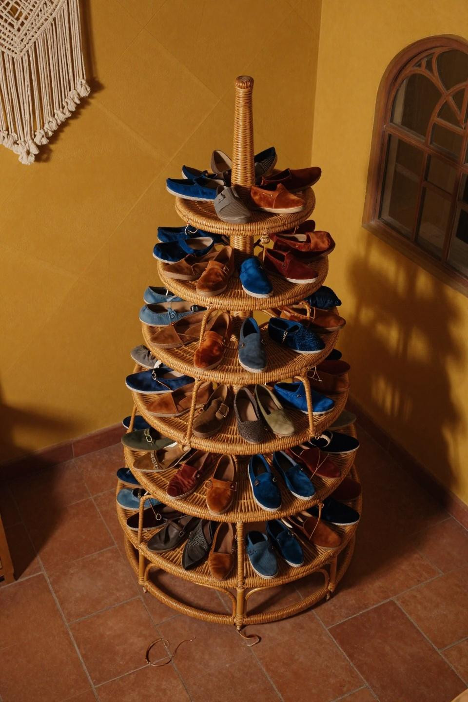 Tiny closet organization with vintage honey-toned rattan woven shoe tower