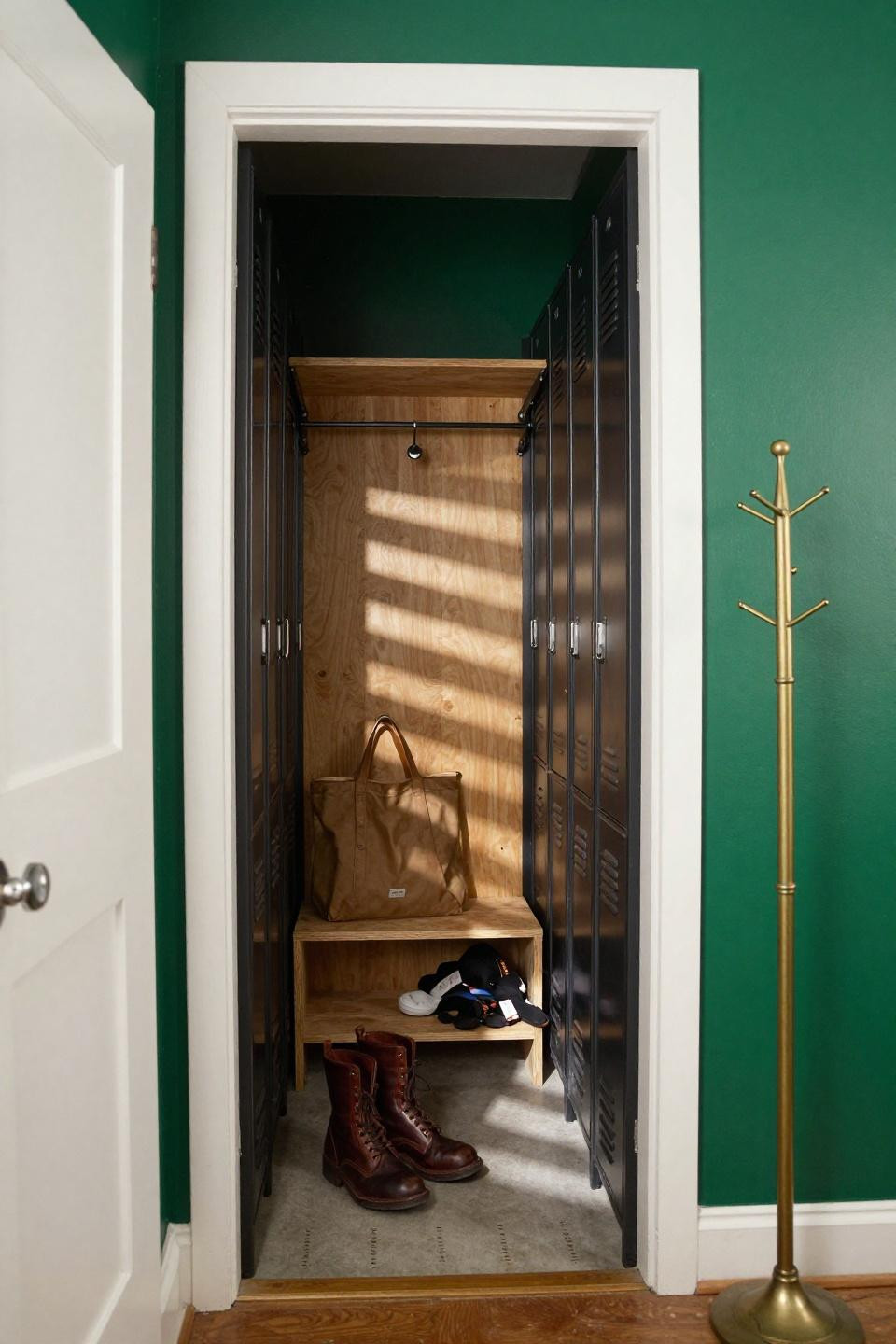 Farmhouse mudroom with deep forest green walls and blackened steel locker bank