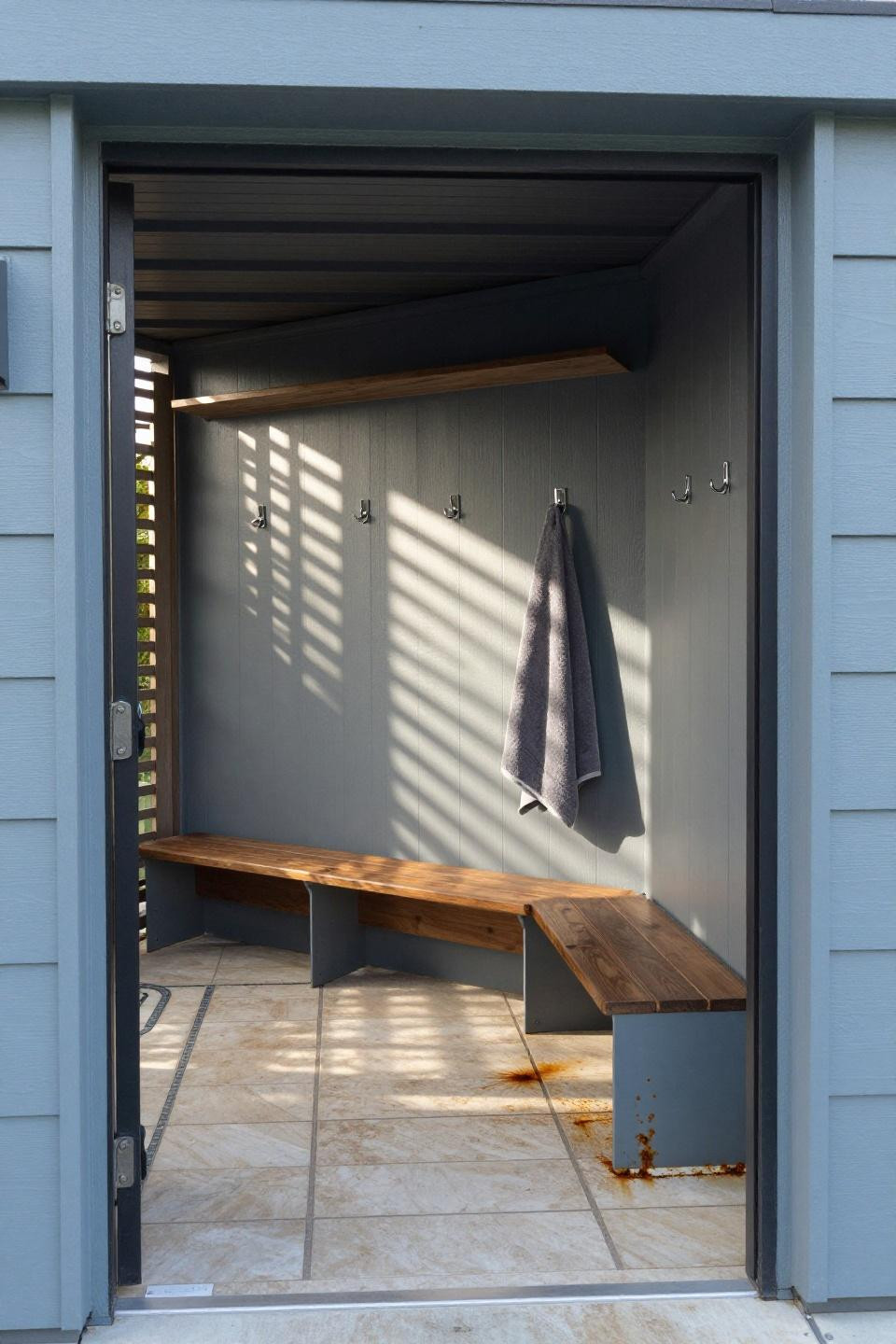 Poolhouse bathrooms with grey-blue painted cladding and teak locker compartments