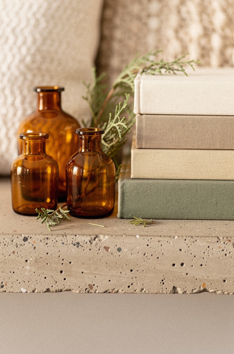Amber demijohns beside stacked books (yes, on concrete)