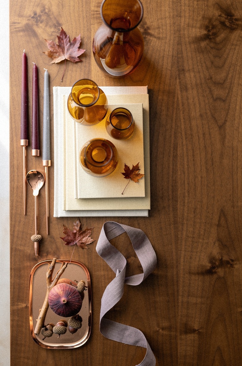 Layer ivory books beneath amber glass vases