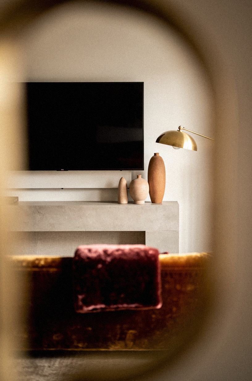 Cluster stoneware vases below one TV edge