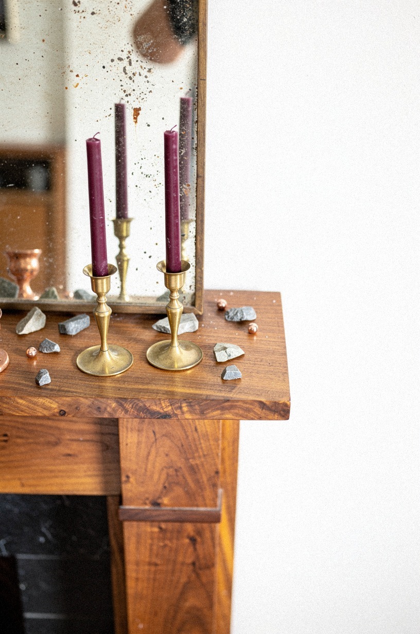 Lean a foxed mirror behind brass candlesticks (Patina Over Polish)