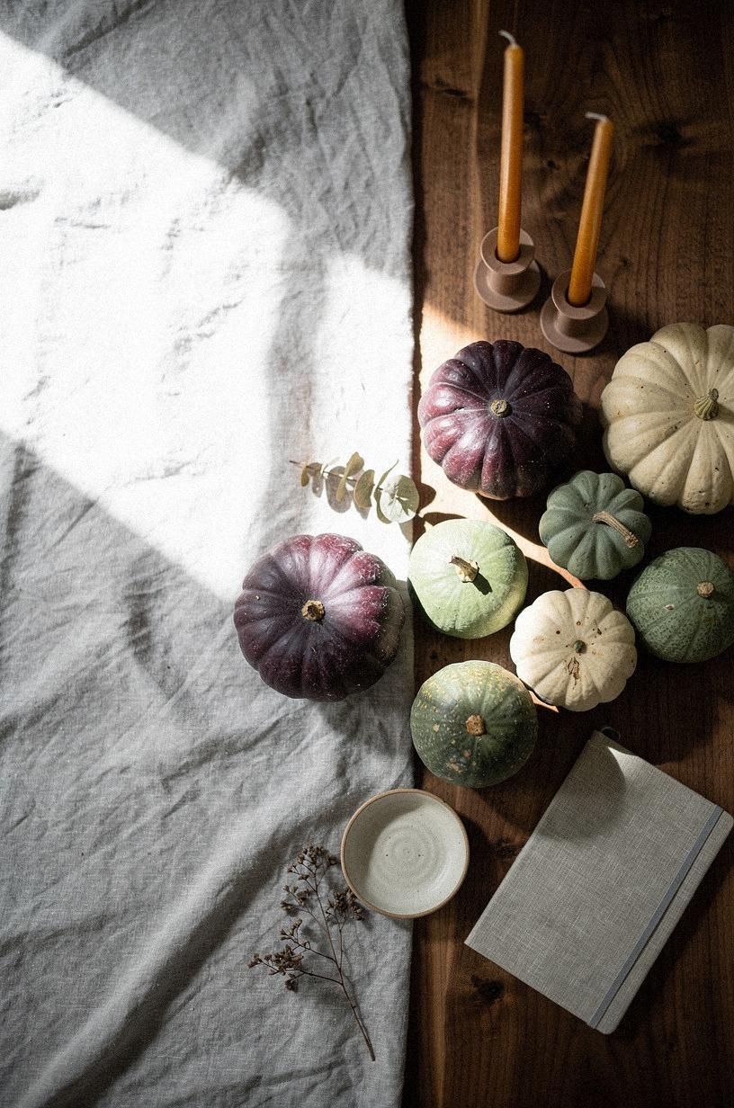 cluster heirloom gourds beside amber tapers