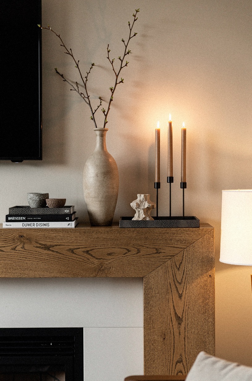 Grouped three taper candles beside the vase