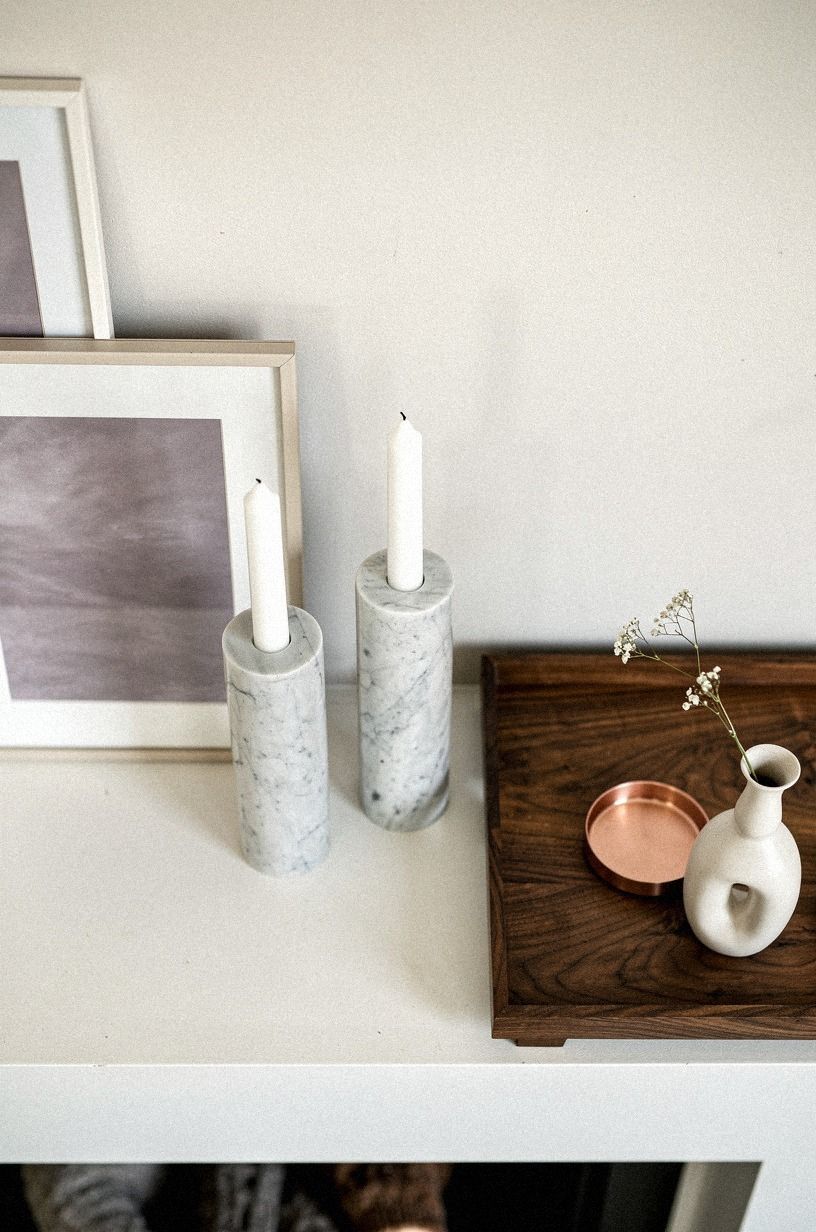 Layer two slim frames behind marble candleholders