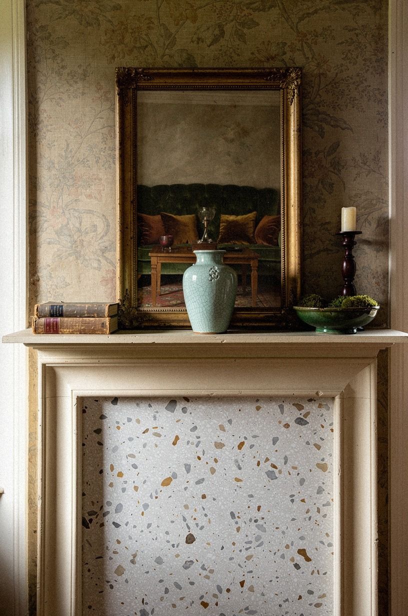 Lean a gilt frame over faded floral wallpaper