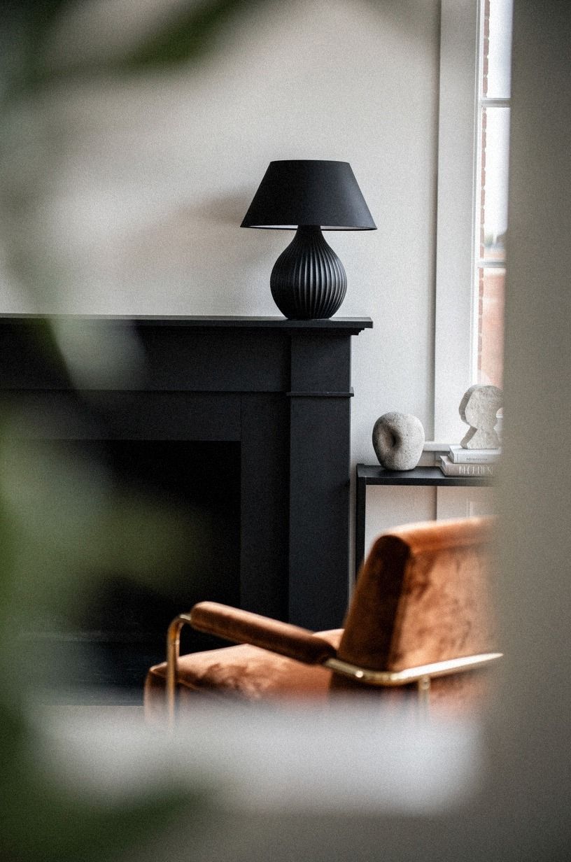 Repeated black with a ribbed ceramic lamp