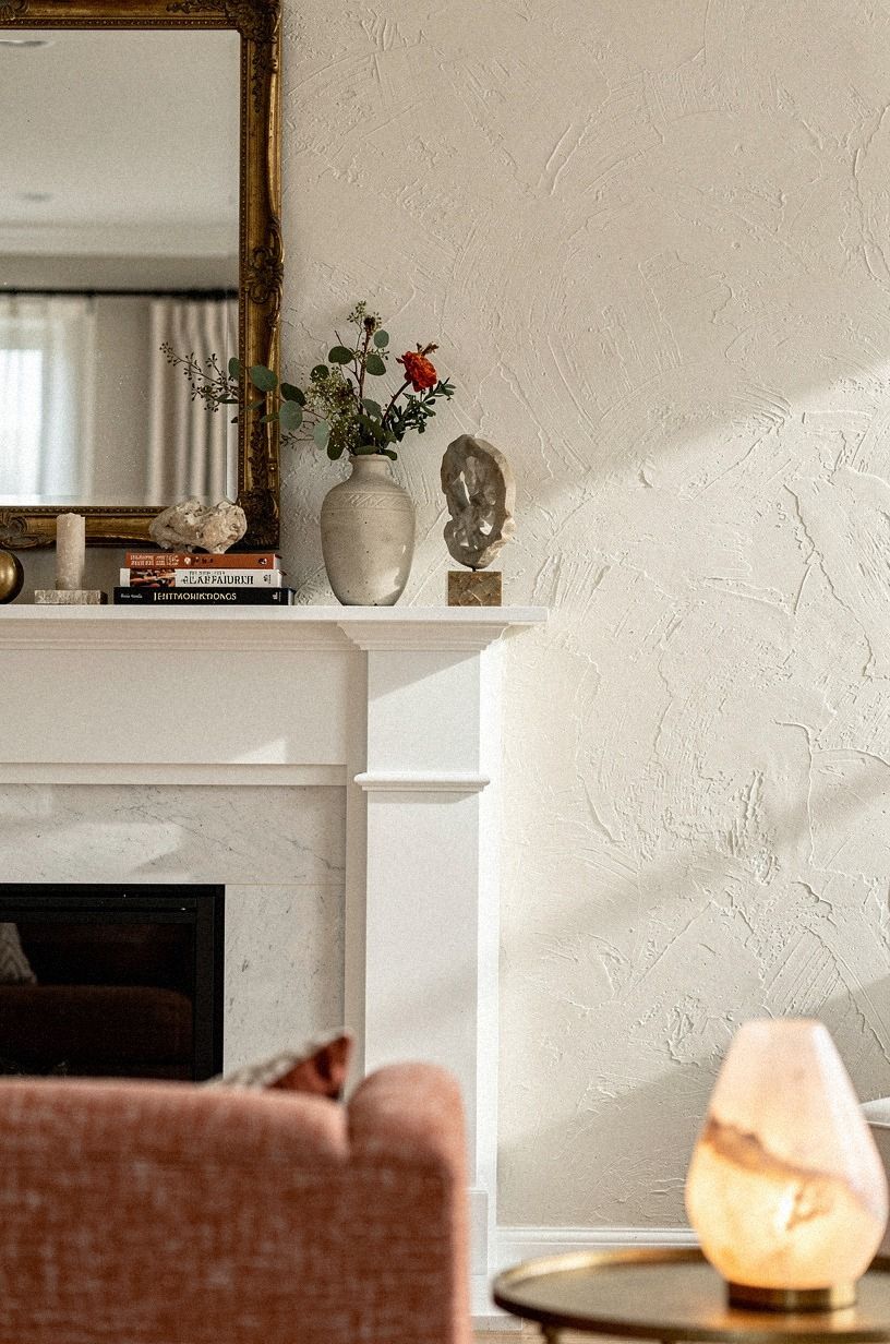 Center a gilded mirror above the white mantel