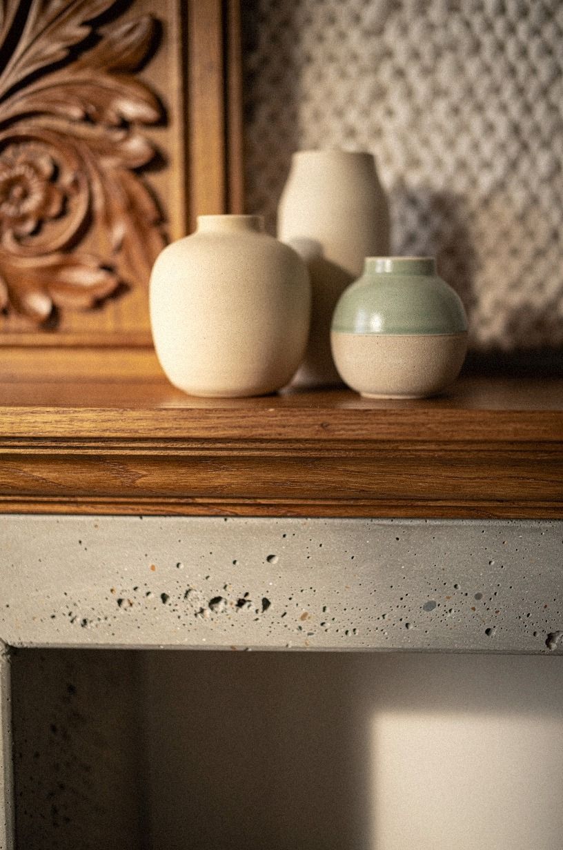Layer carved wood panels behind simple pottery