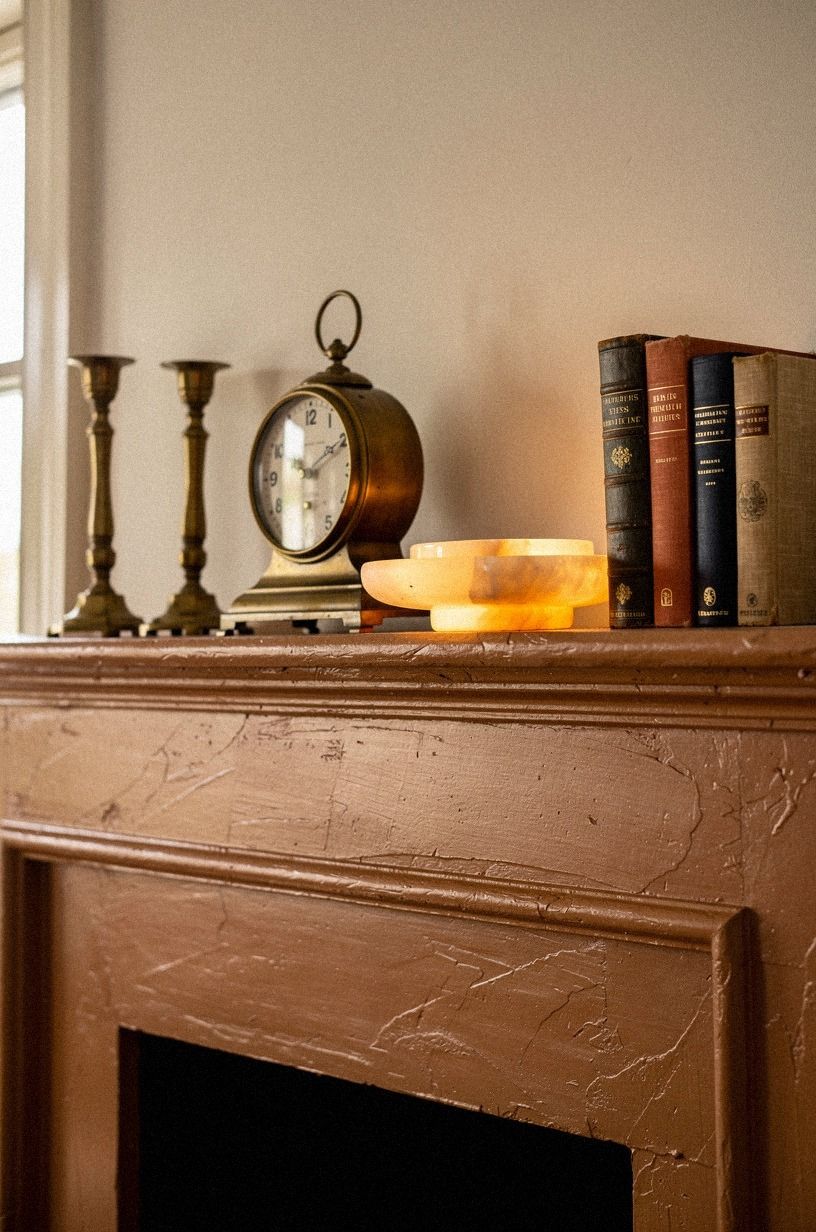Anchor the clock between matching brass candlesticks