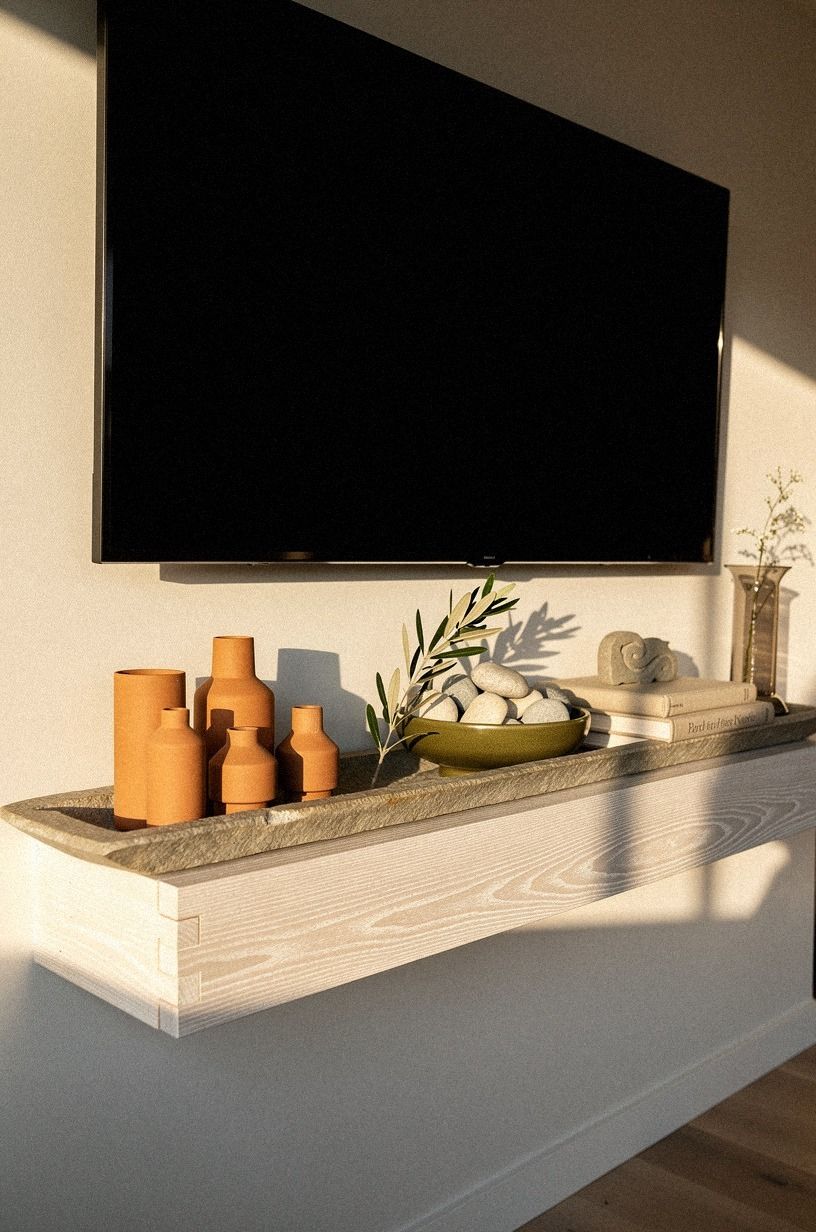 Center a slim stone trough beneath the screen