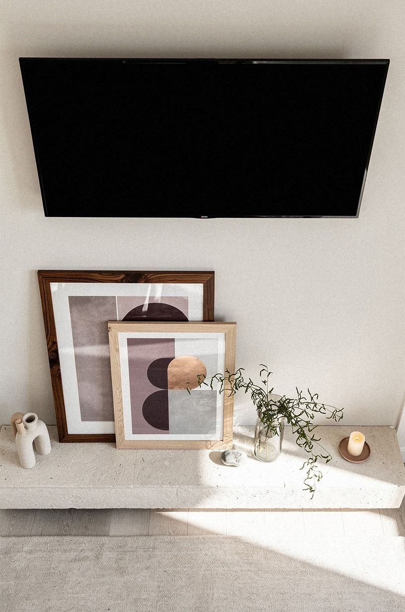 Layer leaning art below the TV