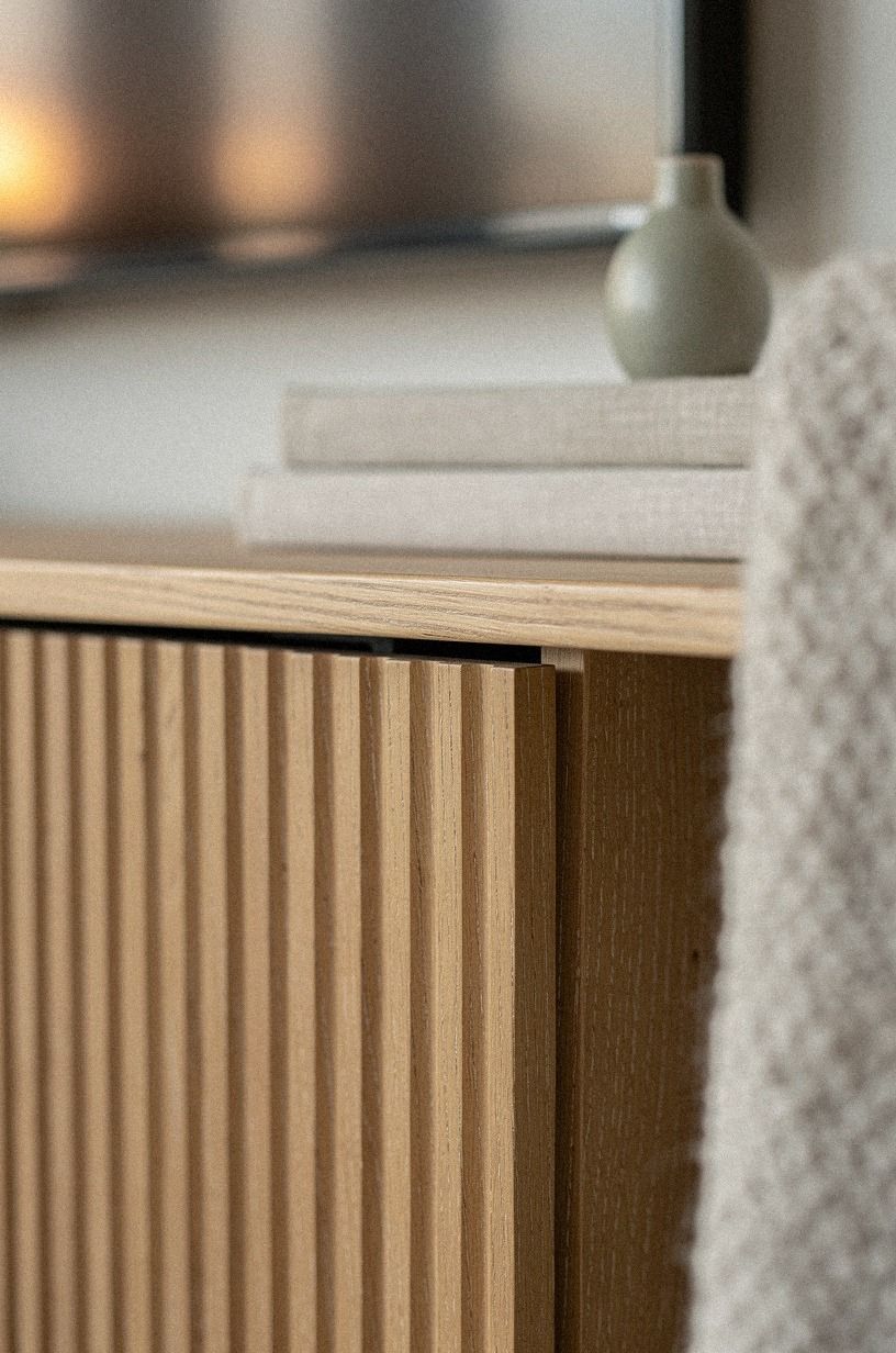Tuck cords behind a fluted wood panel