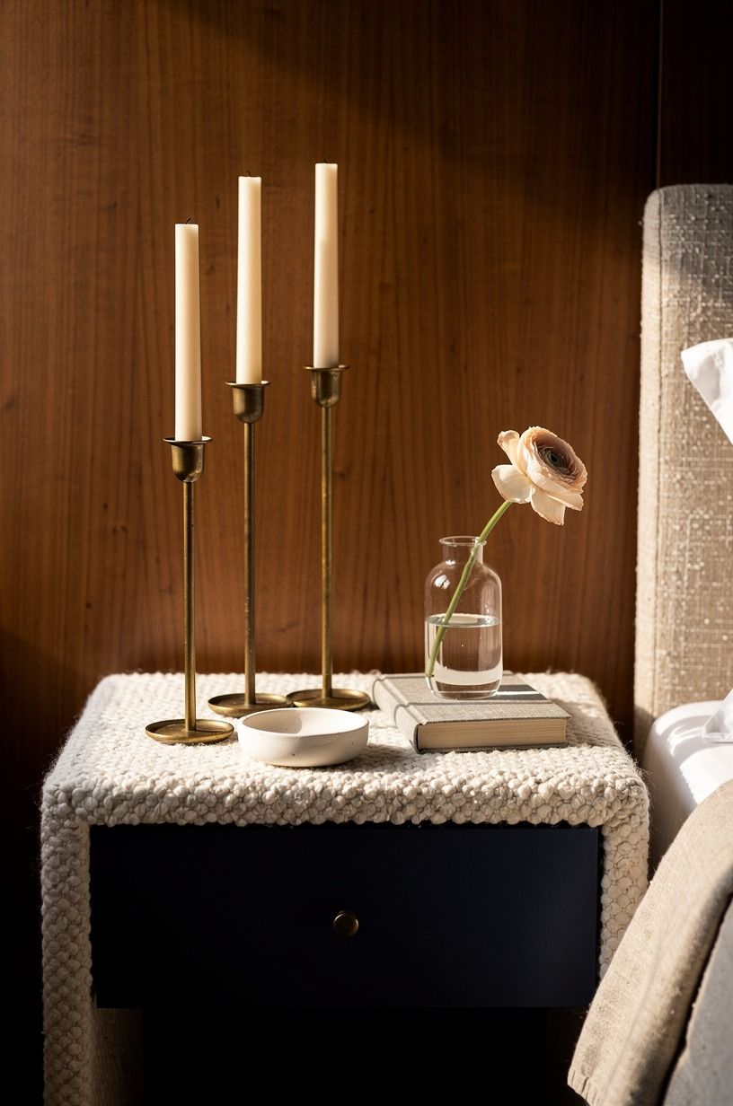 Cluster three brass candlesticks on the nightstand